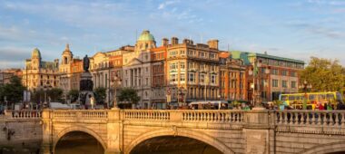 A charming, historic town in Ireland featuring a stone bridge crossing a peaceful river, capturing the inviting atmosphere of the Irish countryside.